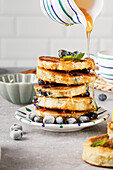 Blaubeer-Pancakes mit Ahornsirup und frischen Blaubeeren