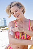 Woman applying sun cream on the beach