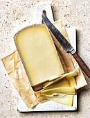 Sliced mature cheese on a chopping board