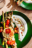 Baked asparagus with feta, cherry tomatoes and yoghurt dip