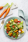 Carrot falafel on salad with yoghurt sauce