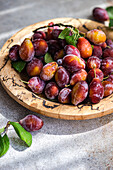 Fresh ripe plums in a wooden bowl