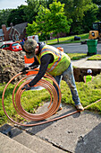 Worker replacing lead water pipes with copper