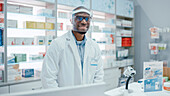 Pharmacist smiling behind counter