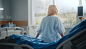 Female patient sitting on hospital bed