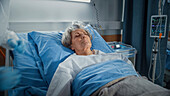 Elderly patient lying in hospital bed