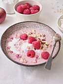 Overnight oats with raspberries, nuts and desiccated coconut