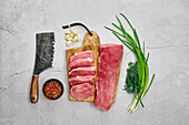 Raw pork fillet and pork chops with herbs