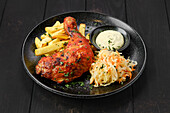 Baked chicken leg with fries, coleslaw and dip