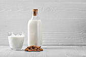 Bottle and glass with almond milk and almonds