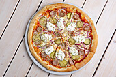 Pizza with sausage, gherkins and sour cream