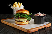 Beef burger with cranberry sauce, cheese and rocket, served with chips and red cabbage salad