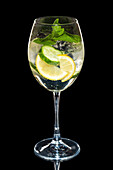 Cocktail with lemon, cucumber and mint in a wine glass