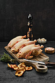 Three raw, whole chickens on a wooden board