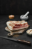 Salted pork belly with caraway seeds on a chopping board