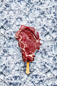 Raw beef chop 'on a stick' on ice cubes