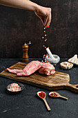 Raw turkey wing being seasoned