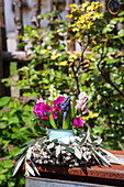 Frühlingsarrangement mit Anemonen und Hyazinthen im Garten