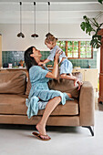 Woman playing with daughter at home