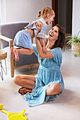 Woman playing with daughter at home