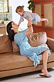 Woman playing with daughter at home