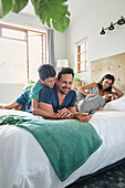 Parents with children relaxing on bed