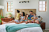 Parents with children relaxing on bed