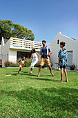 Parents with children playing in backyard