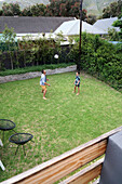 Father and son playing with ball in backyard