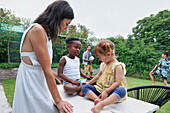 Parents with children playing in backyard