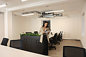 Businesswoman looking at files in conference room