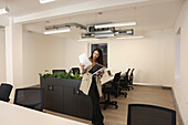 Businesswoman looking at files in conference room