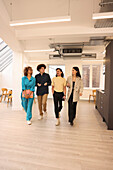 Smiling colleagues walking in modern creative studio