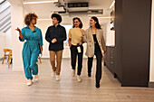 Smiling colleagues walking in modern creative studio