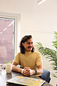 Smiling man sitting in creative office