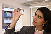 Businesswoman looking at glass cube