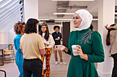 Employee holding coffee during team meeting