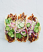 Pulled pork tacos with vegetables and sesame seeds