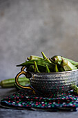 Fresh okra pods in metal bowl