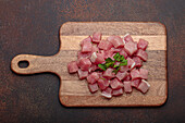 Raw, diced pork on wooden board