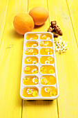 Turmeric and orange juice ice cubes with daisies