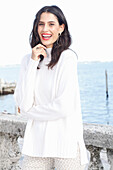 Long-haired young woman in white turtleneck jumper, laughing, red lipstick