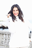 Long-haired young woman in white turtleneck jumper, laughing, red lipstick