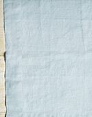 Light grey linen fabric on wooden table as background