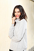 Long-haired young woman in white turtleneck jumper, laughing, red lipstick