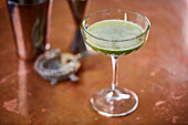 Green cocktail in a coupe glass