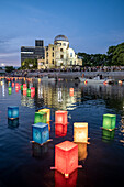 People float lanterns on the river, in front of Atomic Bomb Dome with floating lamps on Motoyasu-gawa River during Peace Memorial Ceremony every August 6 in Hiroshima, Japan