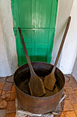 An antique cast iron syrup kettle & wooden paddles in the Museum of the Sugar Industry, San Miguel de Tucumán, Argentina.