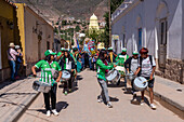 A band of drums and siku panpipes plays for a religious procession in front of the church in Tilcara, Argentina.