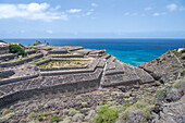 Terrassierte landwirtschaftliche Felder auf vulkanischem Gelände bei Bollullo, Teneriffa. Blick auf den Atlantischen Ozean auf den Kanarischen Inseln, Spanien